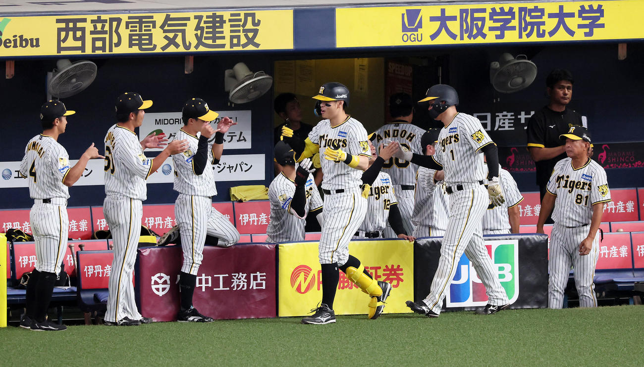 阪神対ヤクルト　6回裏阪神無死一塁、右越え2点本塁打を放った佐藤輝はナインとタッチする。右は森下（撮影・加藤哉）