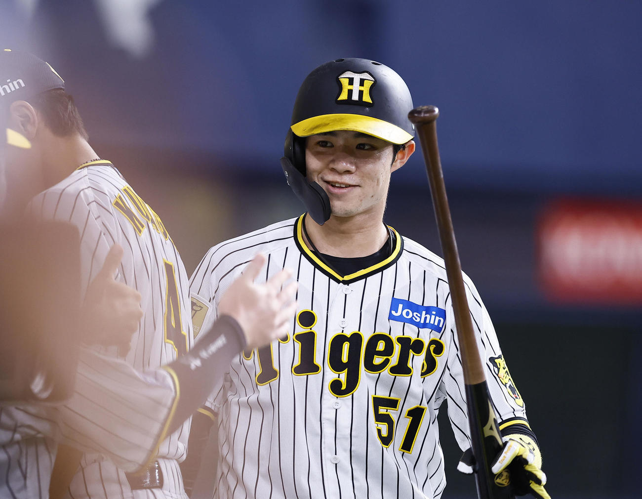 阪神対ヤクルト　1回裏阪神2死二塁、佐藤輝の適時二塁打で生還し、ナインとタッチを交わす中野（撮影・藤尾明華）