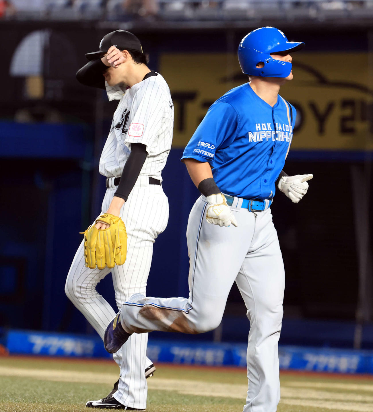 ロッテ対日本ハム　2回表日本ハム無死二塁、レイエスの右適時打で生還した清宮（手前）。奥は佐々木（撮影・浅見桂子）