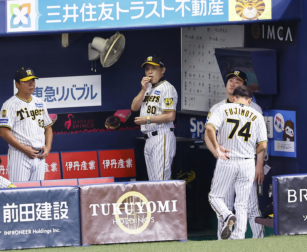 阪神対ヤクルト　8回、ベンチで飴を食べる阪神岡田監督（中央）（撮影・藤尾明華）