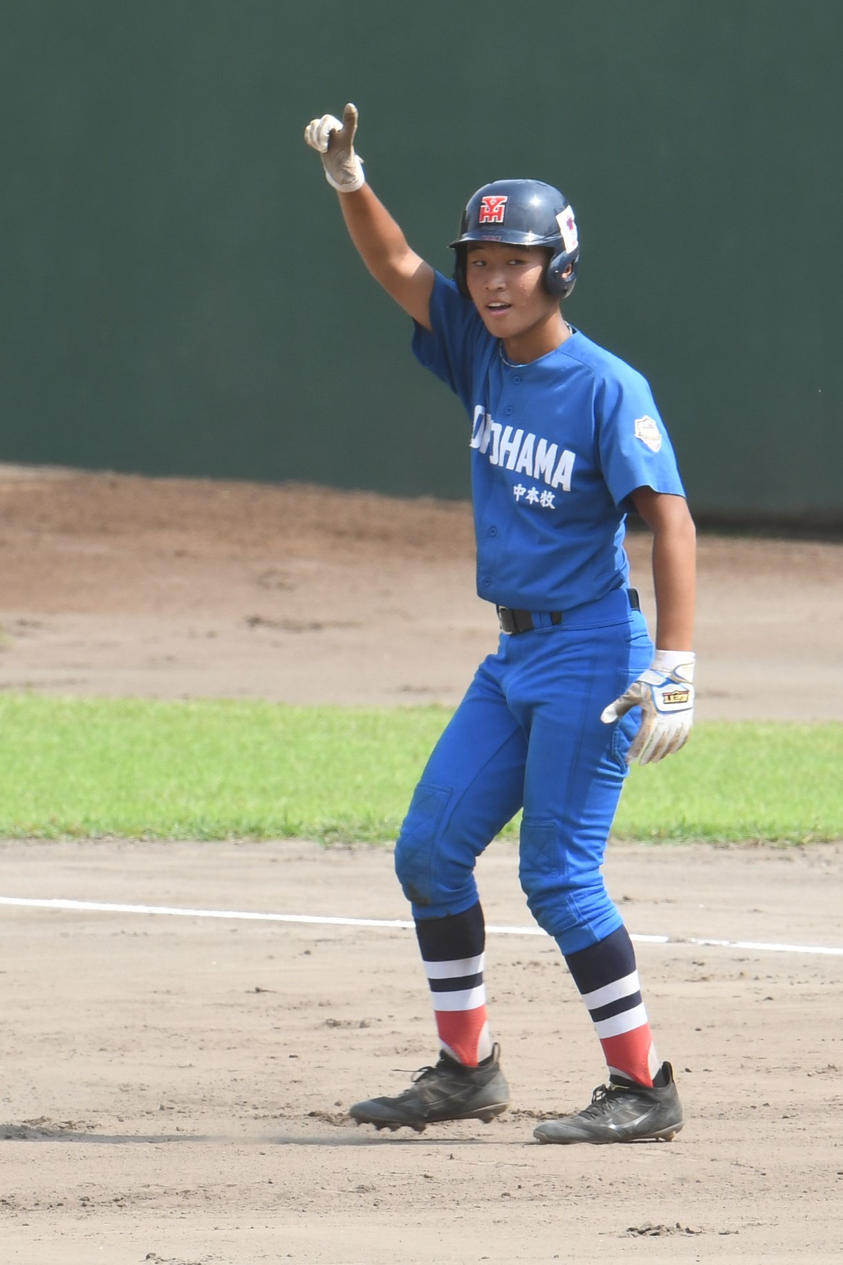 2回に先制打を放った中本牧の陶山暖は一塁ベースに戻りながら1番ポーズ