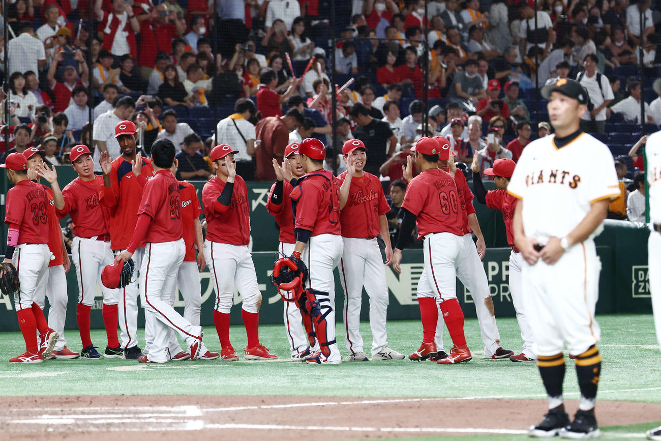 巨人対広島　延長戦の末巨人に勝利し、タッチを交わしていく広島ナイン。手前は阿部監督（撮影・河田真司）