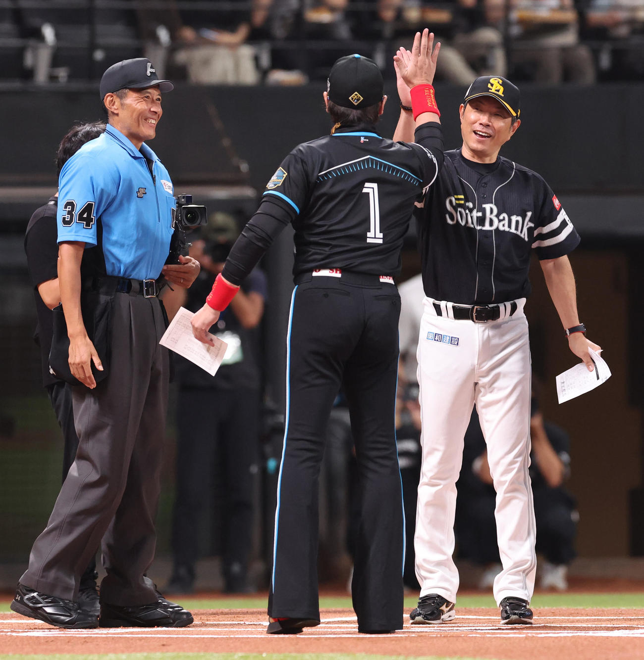 日本ハム対ソフトバンク　メンバー表を交換しハイタッチをする日本ハム新庄監督（左手前）とソフトバンク小久保監督（撮影・佐藤翔太）