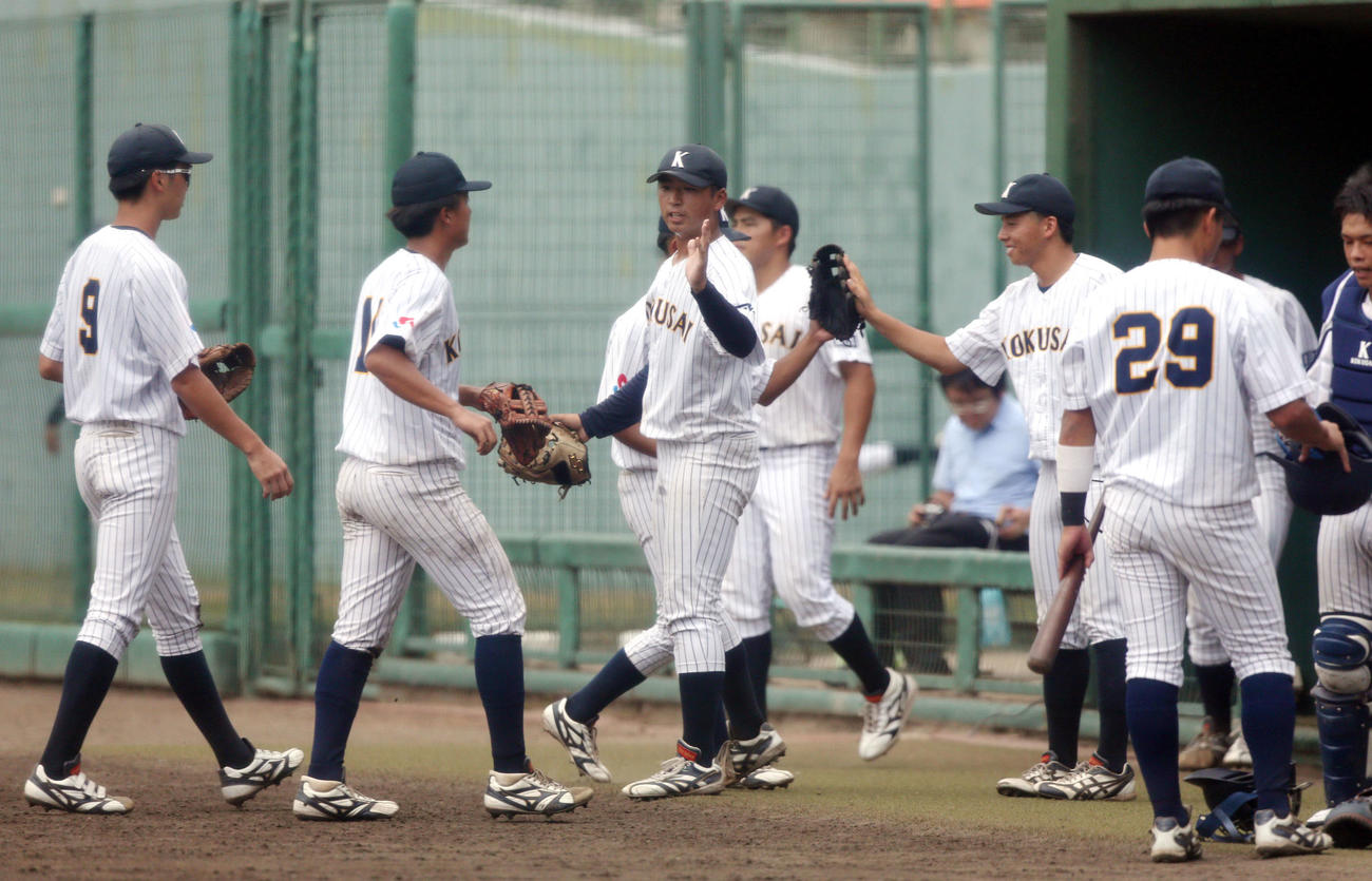 石巻専大対東日本国際大　7回を3者凡退に抑え、チームメートとハイタッチをかわす東日本国際大・藤井（左から3人目）（撮影・木村有優）