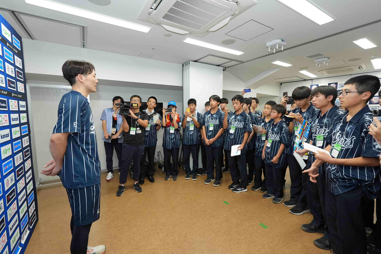 番記者に扮（ふん）したさいたま市立大宮国際中等教育学校の中高生の取材に応じる西武の源田（球団提供）