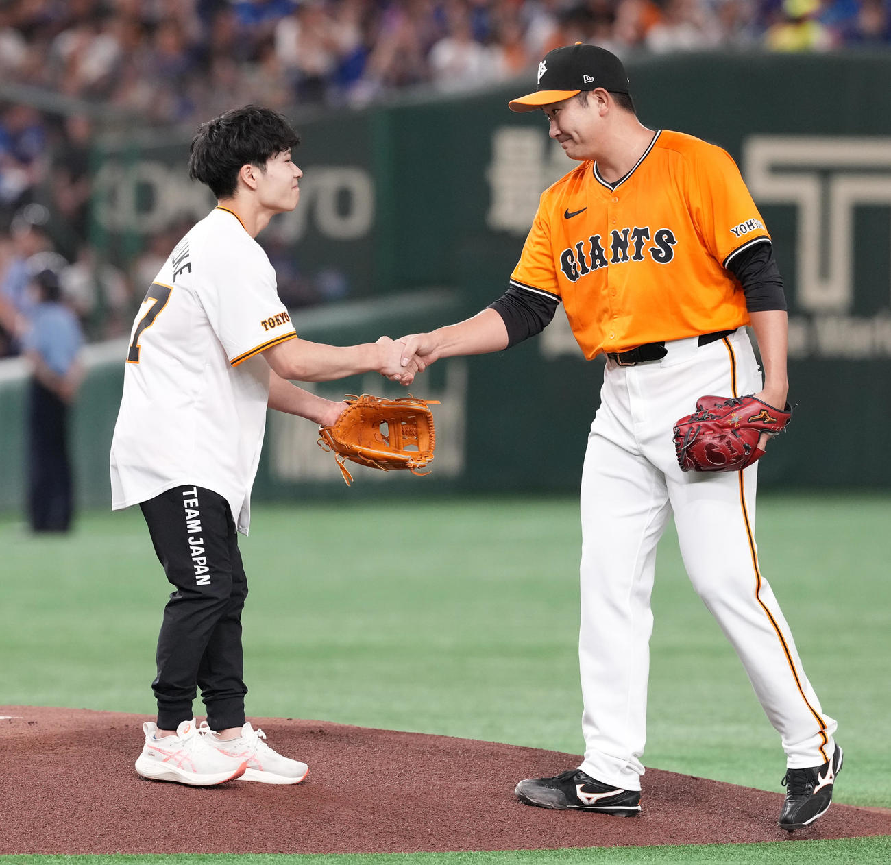 巨人対中日　始球式を終え、巨人先発菅野（右）と握手するパリ五輪体操男子日本代表の岡（撮影・鈴木みどり）