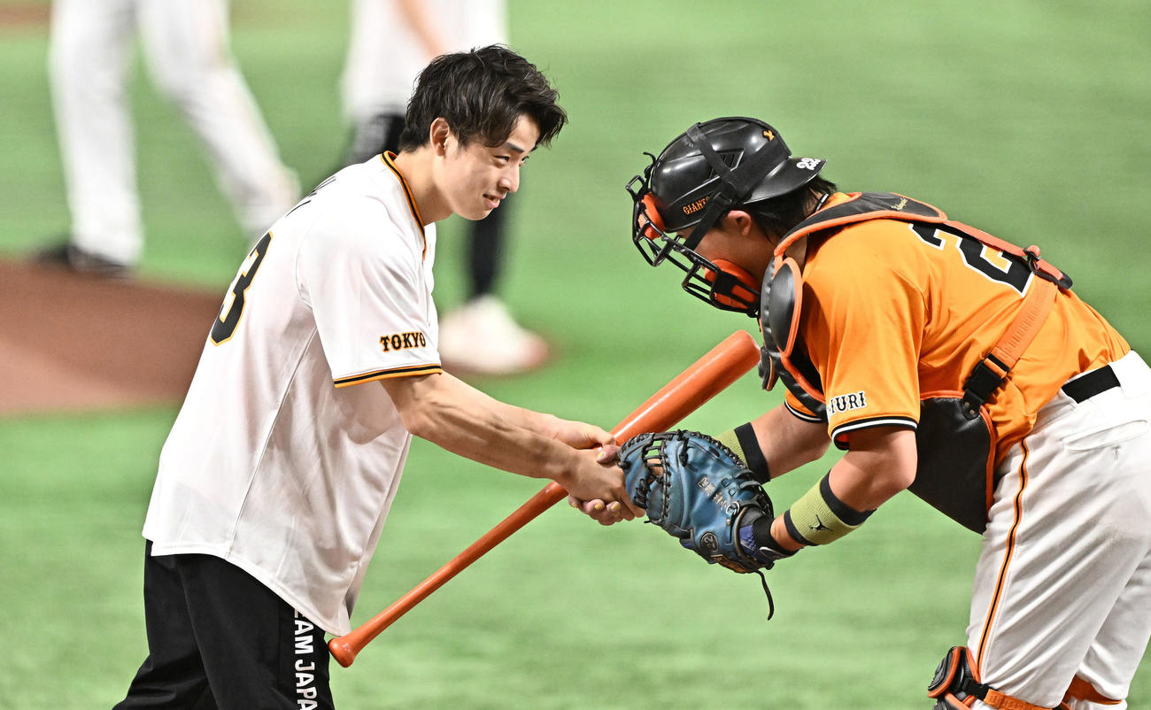 巨人対中日　セレモニアルピッチで打席に立った体操男子日本代表の杉野（左）は巨人小林と握手を交わす（撮影・滝沢徹郎）