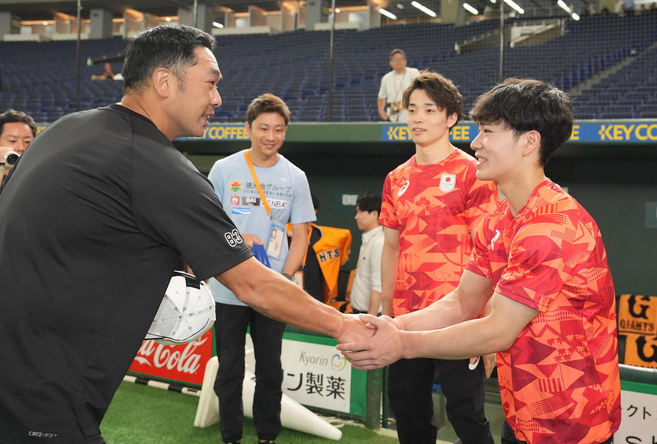 巨人阿部監督（左）と握手するパリ五輪体操男子日本代表の岡。右奥は杉野（撮影・鈴木みどり）