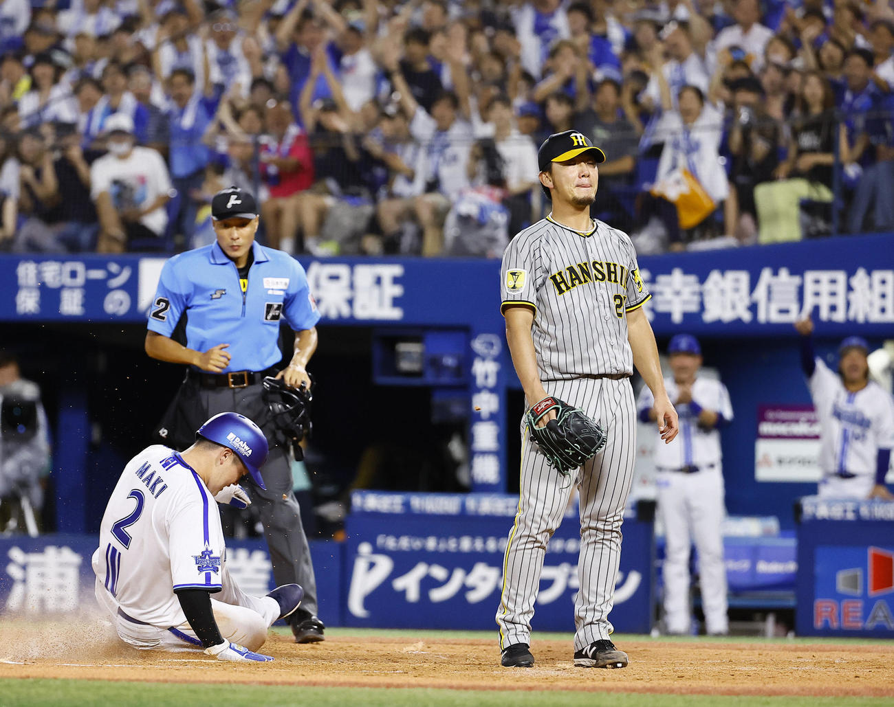 DeNA対阪神　3回裏DeNA2死一、二塁、暴投で牧（左）が生還しぼうぜんとする伊藤将（撮影・藤尾明華）
