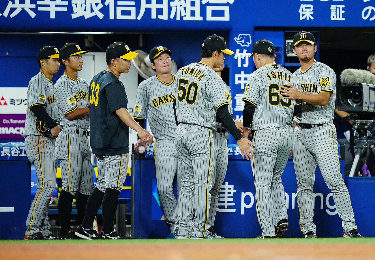 DeNA対阪神　7回裏DeNA2死一塁、降板した石井（右から2人目）をねぎらう伊藤将（同端）ら選手たち（撮影・垰建太）