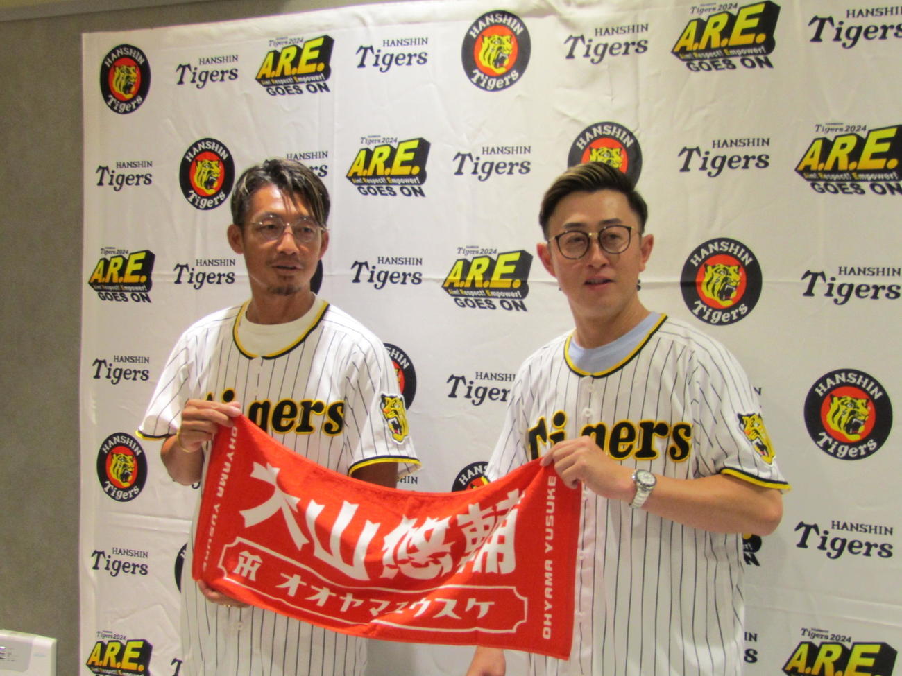 リニューアルオープンした「タイガースショップ」のグッズを手にアピールする鳥谷氏（左）と今成氏（撮影・高垣誠）