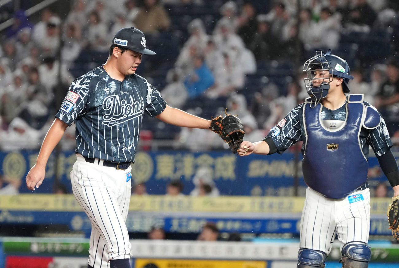 ロッテ対西武　4回の投球を終えグラブタッチする西武先発の渡辺（左）と古賀（撮影・小沢裕）