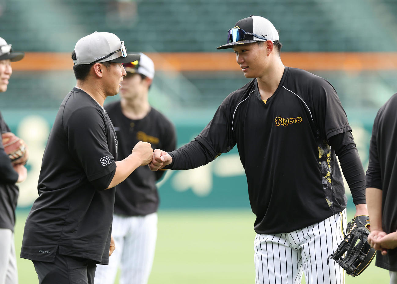 阪神対巨人　練習でグータッチを交わす巨人浅野（左）と阪神森下（撮影・前田充）
