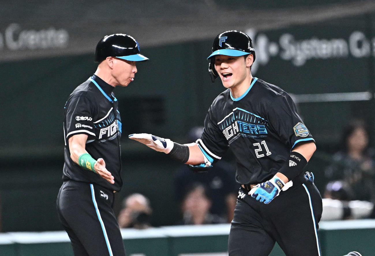 西武対日本ハム　3回表日本ハム1死一、二塁、先制3点本塁打を放った清宮（右）は森本コーチとタッチをかわす（撮影・滝沢徹郎）