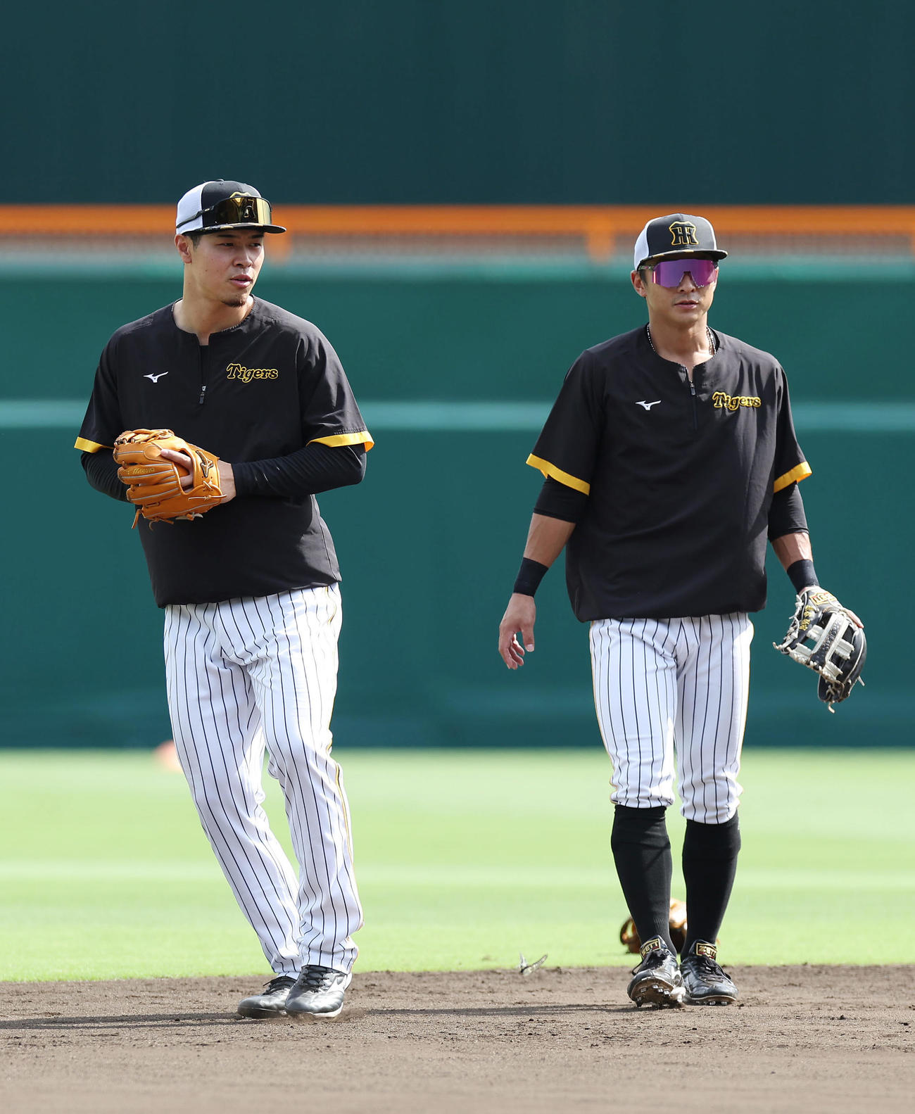 阪神対巨人　ノックを受けた後、阪神熊谷（右）と言葉を交わす佐藤輝（撮影・前田充）