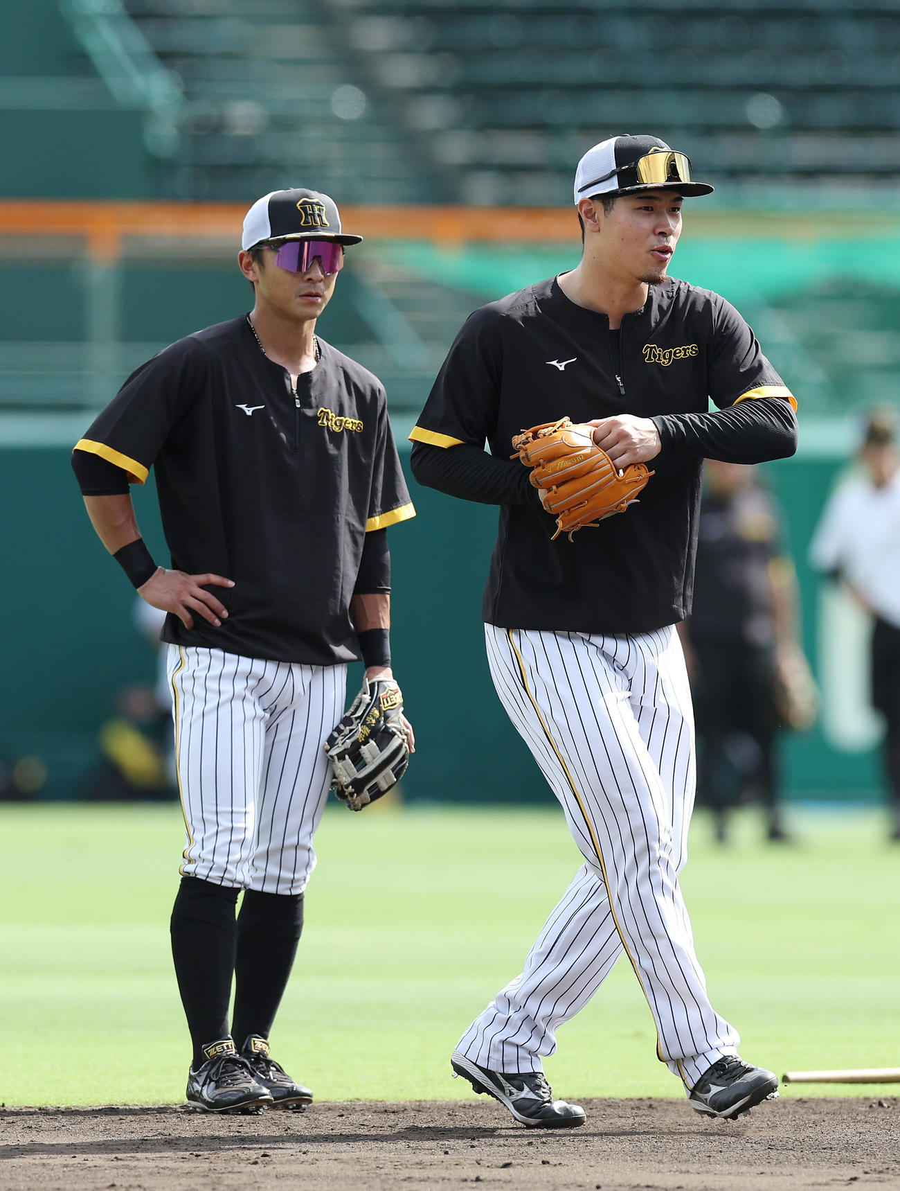 阪神対巨人　ノックを受けた後、阪神熊谷（左）と言葉を交わす佐藤輝（撮影・前田充）