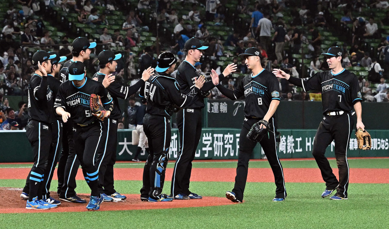 西武対日本ハム　8セーブ目をマークした柳川（右から3人目）はチームメートとタッチをかわす（撮影・滝沢徹郎）