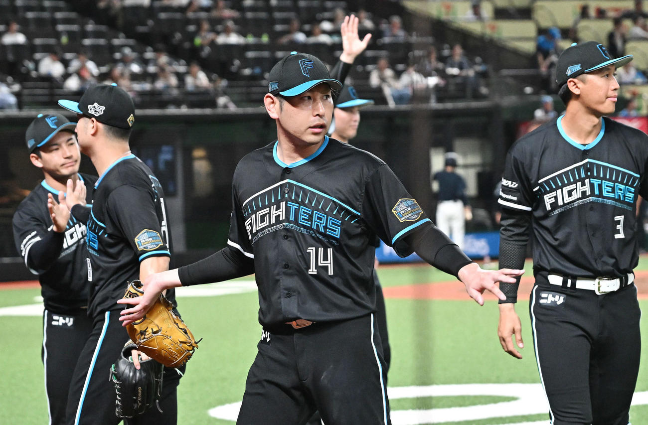 西武対日本ハム　5回裏を投げ終えた日本ハム先発の加藤貴（中央）はチームメートとタッチをかわす（撮影・滝沢徹郎）