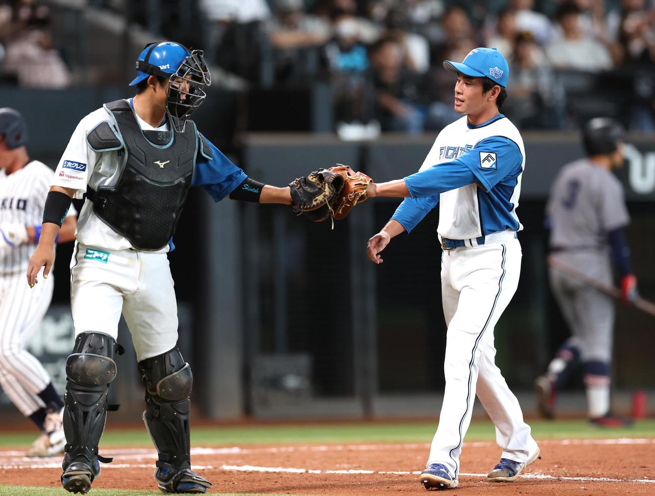 日本ハム2軍対東京6大学選抜　7回に登板し無失点に抑え進藤とタッチする宮内（撮影・黒川智章）