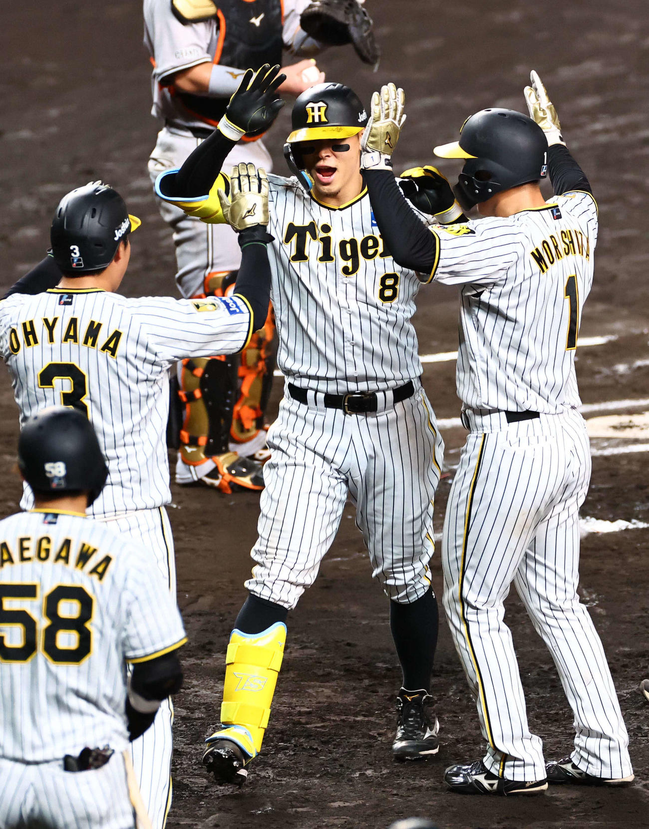 阪神対巨人　6回裏阪神2死一、二塁、逆転3点本塁打を放った佐藤輝（中央）は大山（左）森下（右）とハイタッチ（撮影・上田博志）