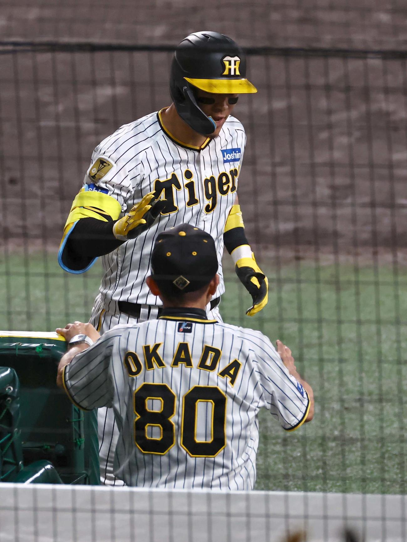 阪神対巨人　6回裏阪神2死一、二塁、逆転3点本塁打を放った佐藤輝は岡田監督とハイタッチする（撮影・上田博志）