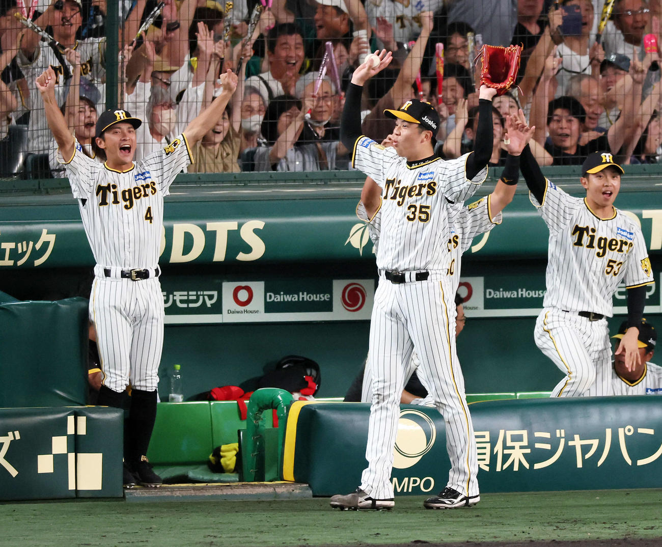 阪神対巨人　6回裏阪神2死一、二塁、才木は佐藤輝の本塁打にベンチ前でバンザイ。左は熊谷、右は島田（撮影・加藤哉）