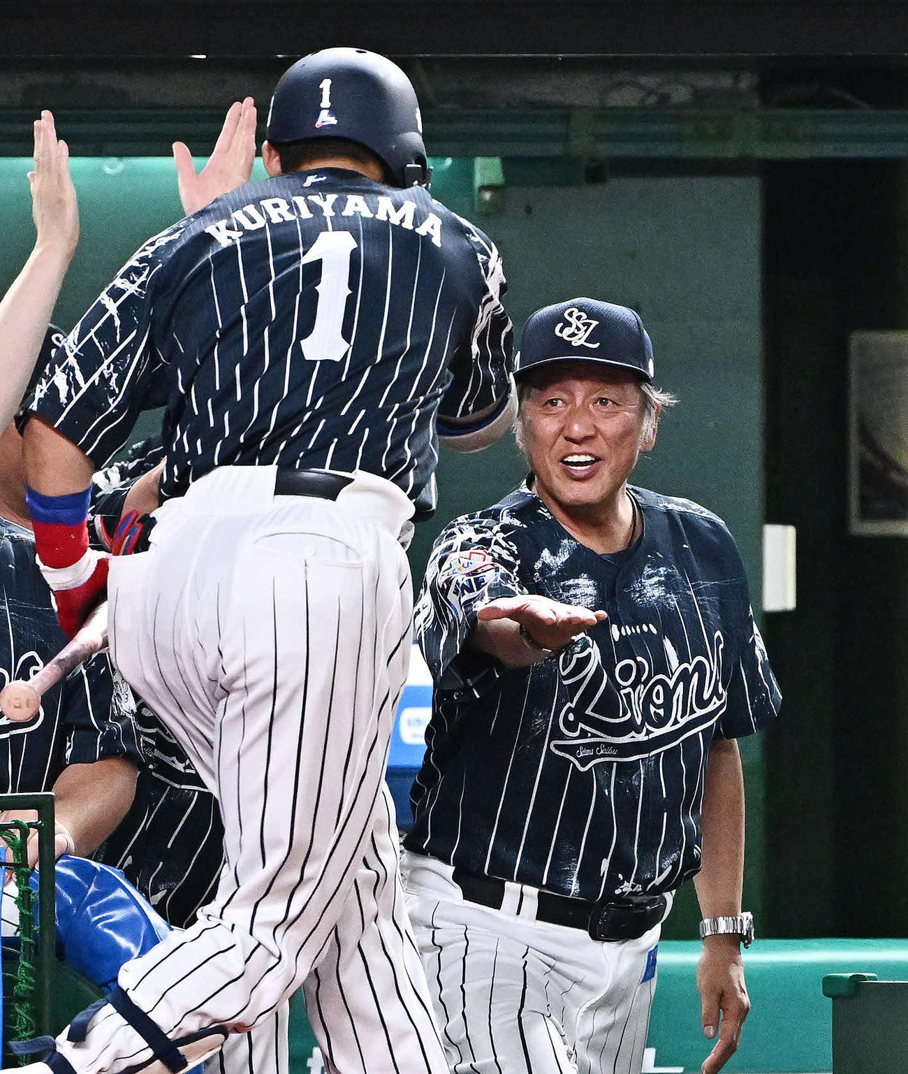 西武対日本ハム　8回裏西武2死三塁、右越え2点本塁打を放った代打栗山（手前）を迎える渡辺GM兼監督代行（撮影・滝沢徹郎）
