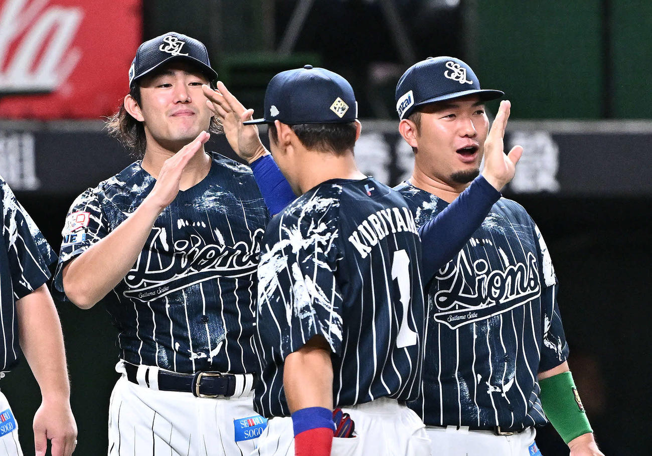西武対日本ハム　試合後、西武今井（左）は栗山（中央）とタッチをかわす（撮影・滝沢徹郎）