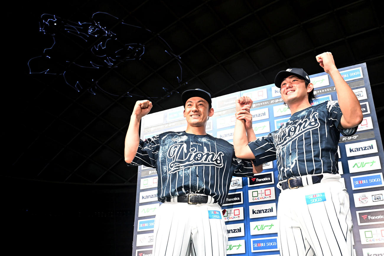 西武対日本ハム　ヒーローインタビューを終えレーザー光線で描かれた獅子を背にポーズを決める西武栗山（左）と今井（撮影・滝沢徹郎）