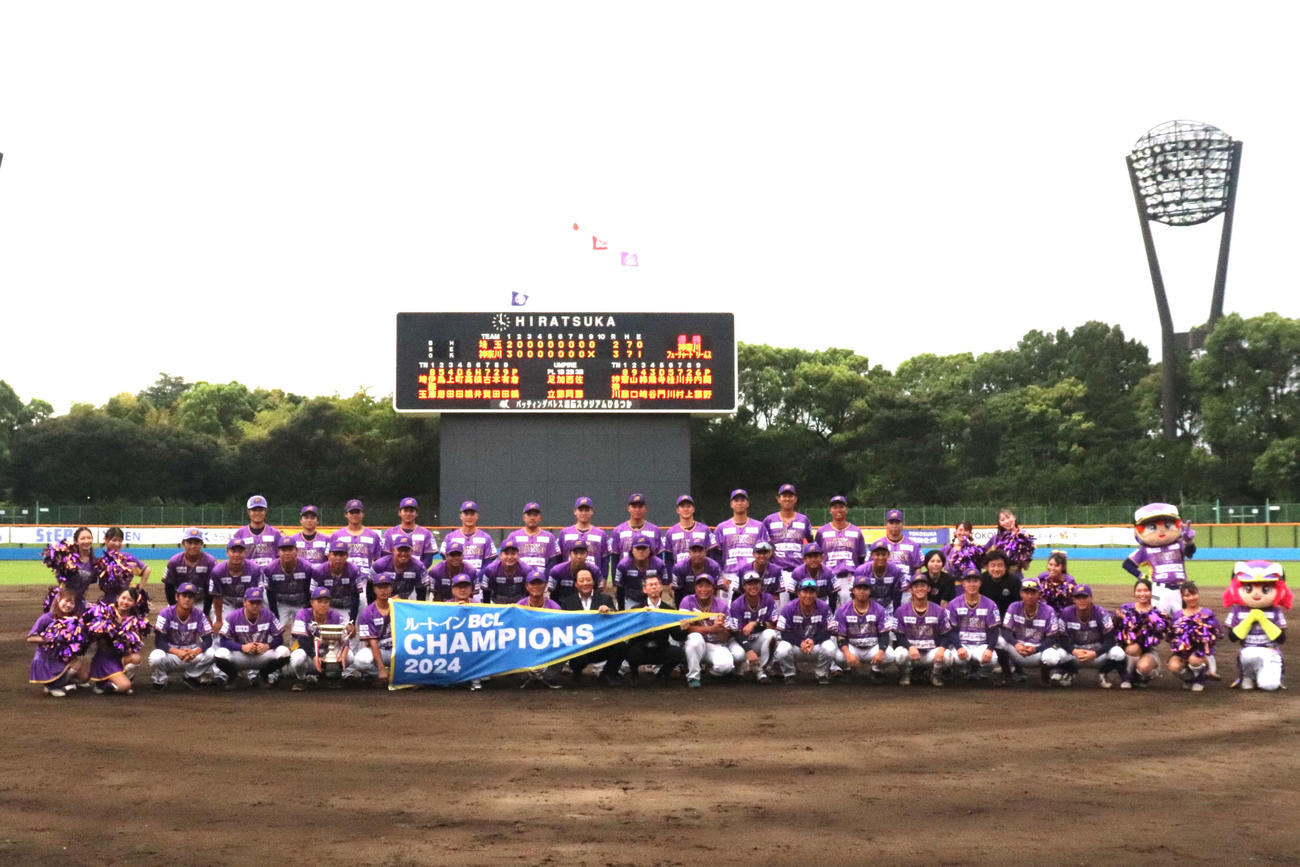優勝を決め、チャンピオンフラッグを手に集合写真に写る選手、関係者（撮影・保坂淑子）