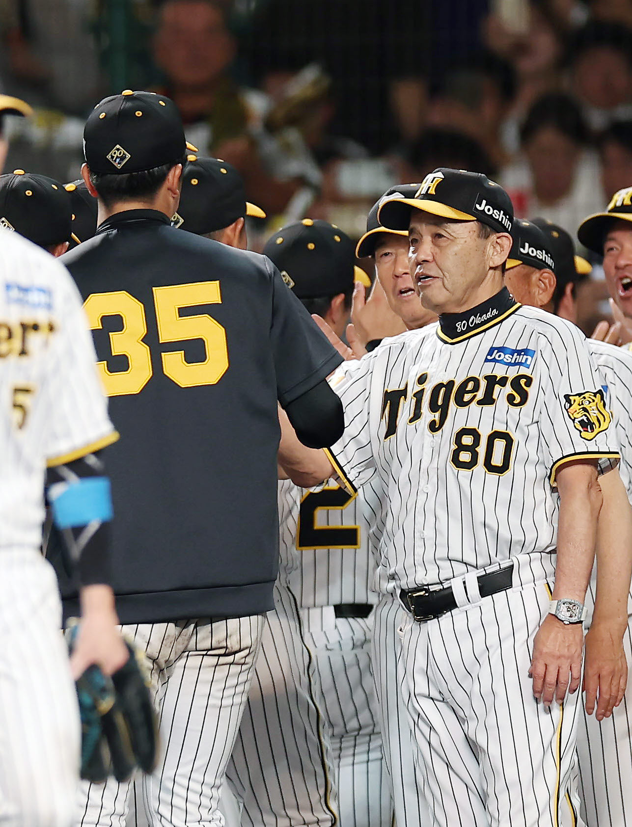 阪神対巨人　巨人に勝利し、阪神才木（左）とタッチを交わす岡田監督（撮影・前田充）