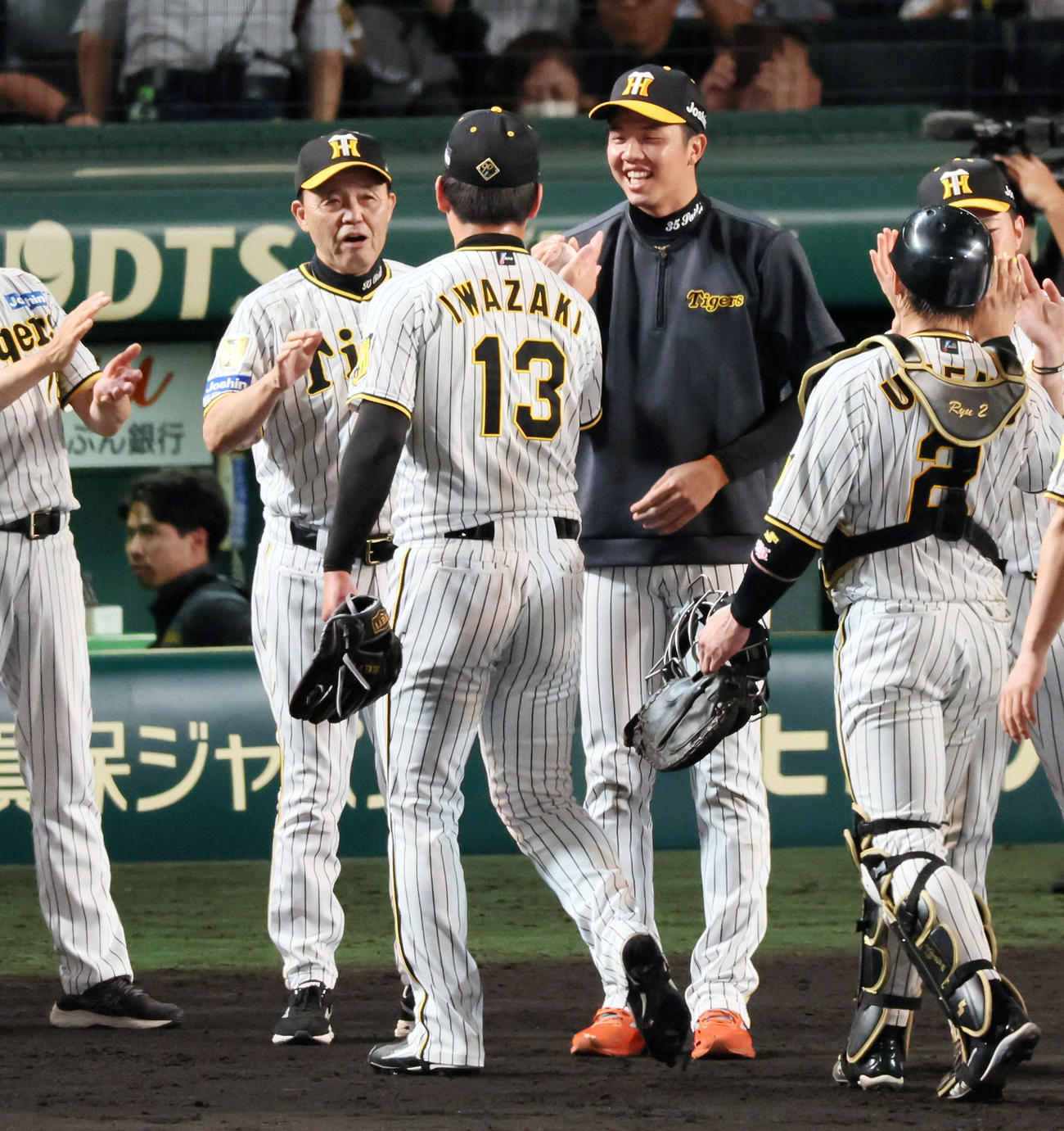 阪神対巨人　巨人に勝利し、才木は岩崎からウイニングボールを手渡される。左は岡田監督（撮影・加藤哉）