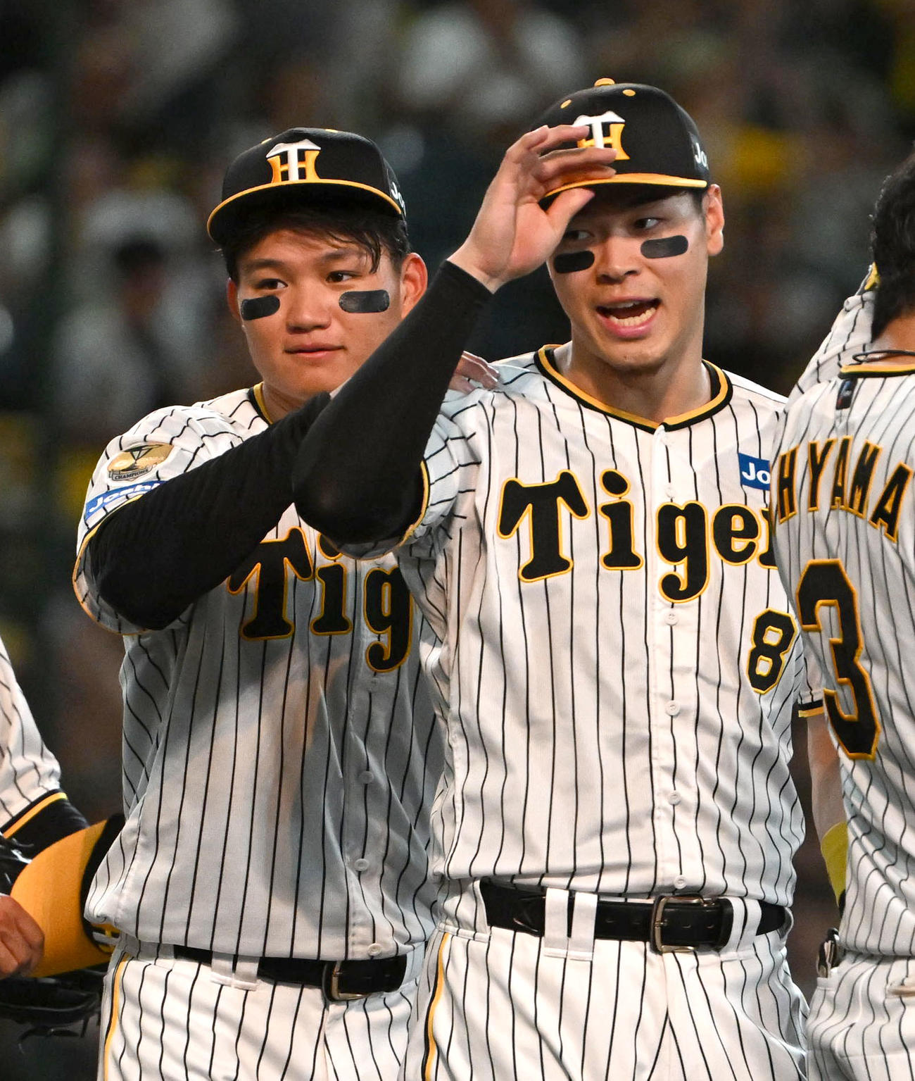 阪神対巨人　巨人に勝利し佐藤輝（右）の肩を揉む森下（撮影・石井愛子）