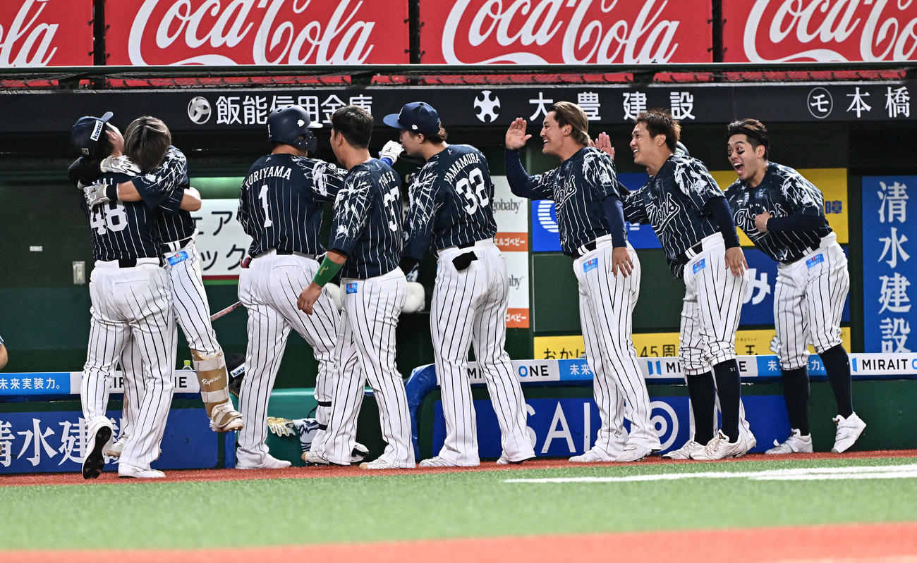 西武対日本ハム　8回裏西武2死三塁、右越え2点本塁打を放った代打栗山（左から3人目）は生還しチームメートとタッチをかわす（撮影・滝沢徹郎）