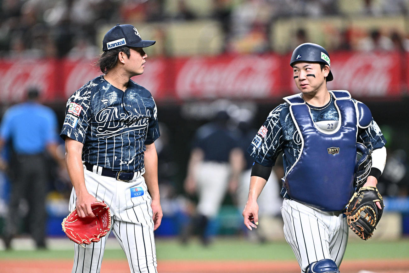 西武対日本ハム　1回表を投げ終えた西武先発の今井（左）は古賀と引き揚げる（撮影・滝沢徹郎）