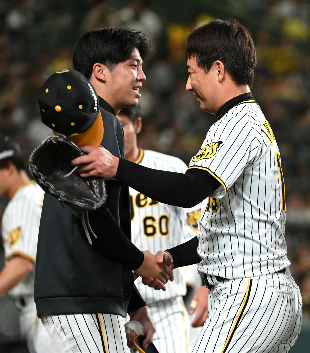 阪神対巨人　巨人に勝利し才木（左）は岩崎と握手（撮影・石井愛子）