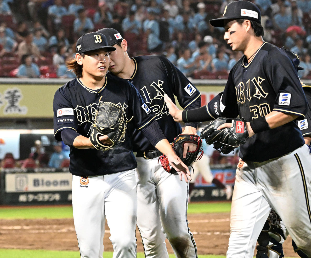 楽天対オリックス　8回裏の投球を終え、広岡大志（右）らナインをタッで迎える宮城大弥＝2024（左）（撮影・千葉一成）