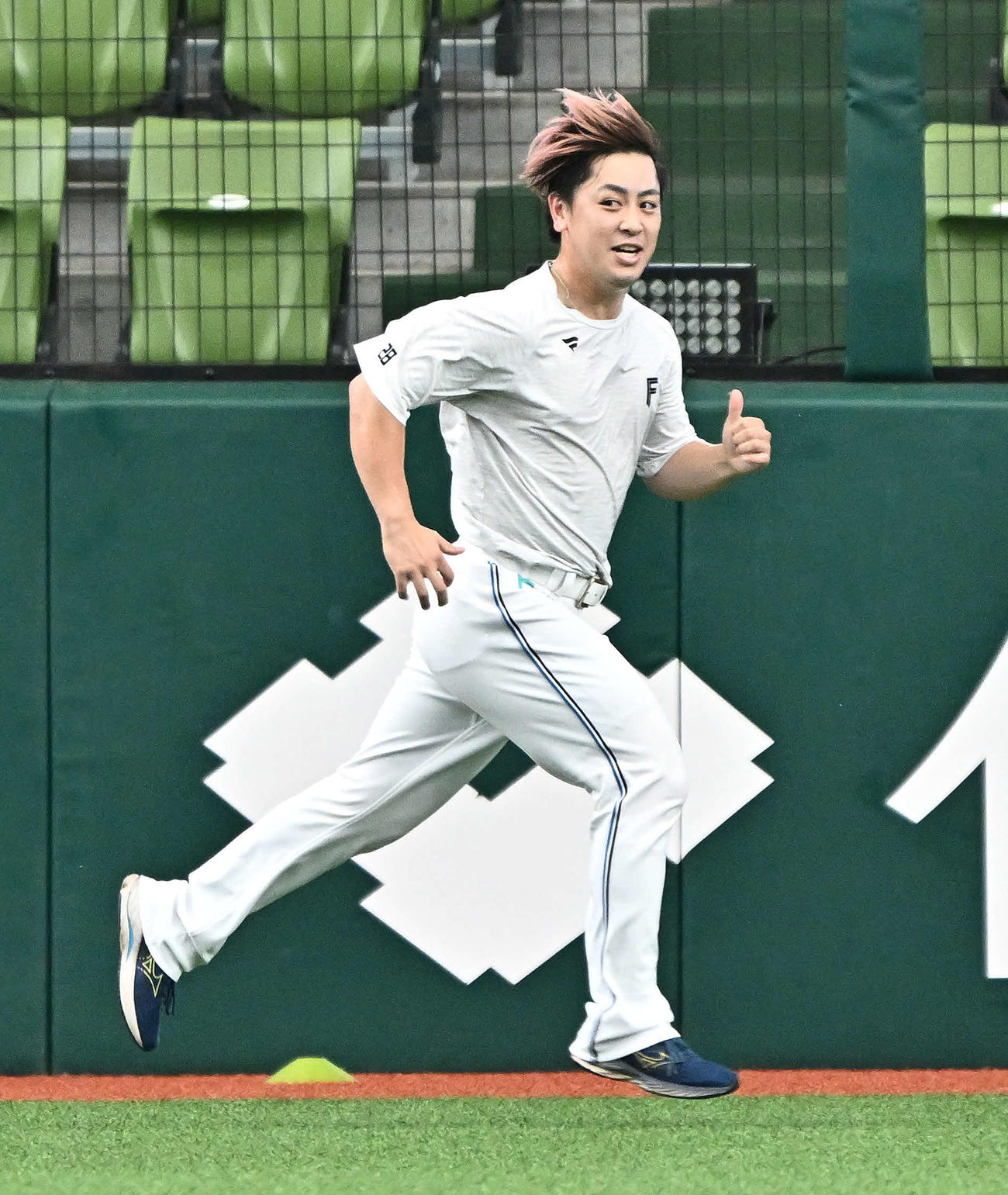 西武対日本ハム　試合前練習で髪をなびかせて走る日本ハム河野（撮影・滝沢徹郎）