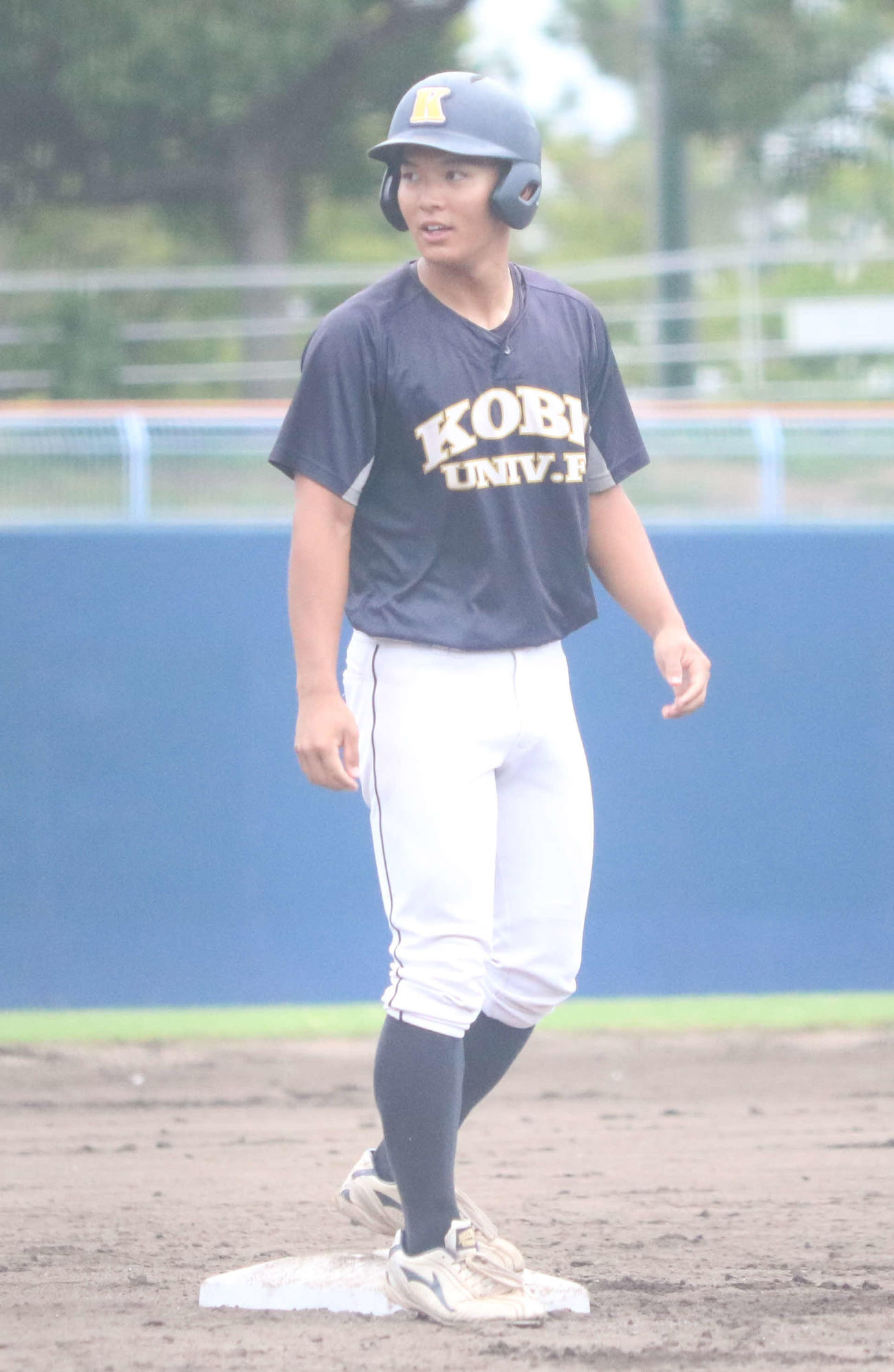 神戸医療未来大対大阪観光大　4回表神戸医療未来大2死一、二塁、右中間へ2点適時三塁打を放ち塁上からベンチを見る新鞍（撮影・塚本光）