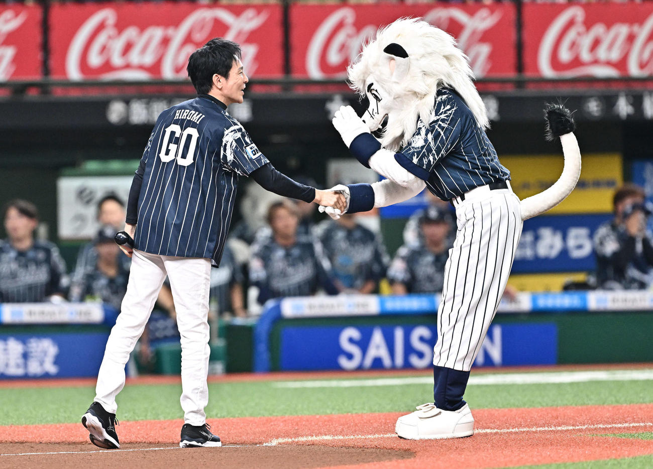 西武対日本ハム　試合前のセレモニアルバッテイングを終えた郷ひろみ（左）はレオと握手を交わす（撮影・滝沢徹郎）