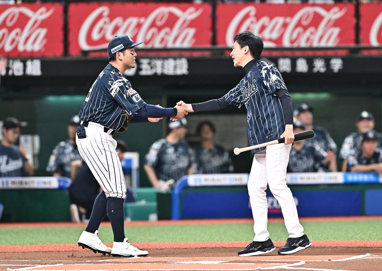 西武対日本ハム　試合前のセレモニアルバッテイングを終えた郷ひろみ（右）は捕手を務めた西武蛭間と握手を交わす（撮影・滝沢徹郎）