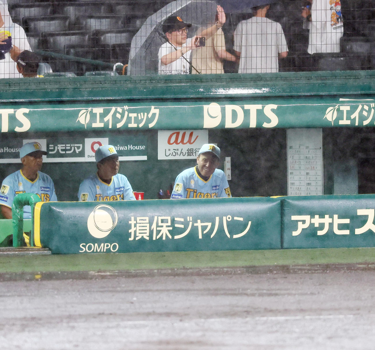 阪神対巨人　7回裏を終え降雨中断となりベンチからグラウンドを見る岡田監督。左は平田ヘッドコーチ（撮影・加藤哉）