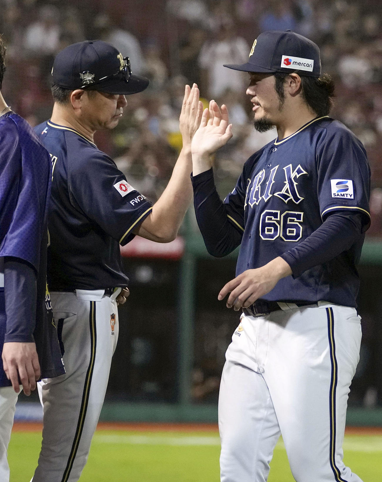 移籍後初勝利を挙げ中嶋監督（左）とタッチを交わすオリックス鈴木（共同）