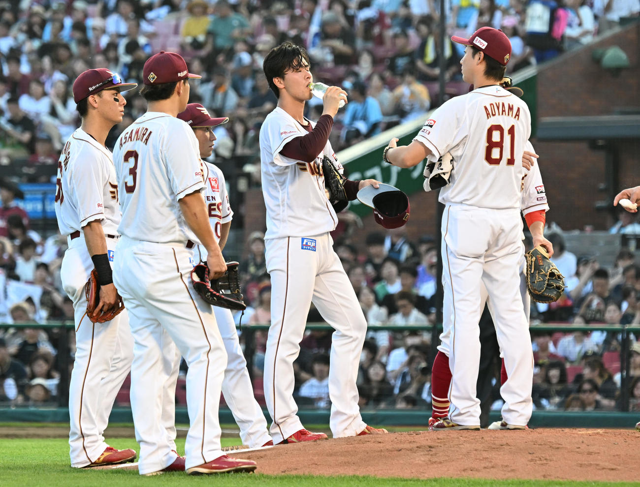 楽天対オリックス　5回表オリックス無死満塁、ピンチを迎え、集まった内野陣の輪の中で水を飲む古謝（撮影・千葉一成）