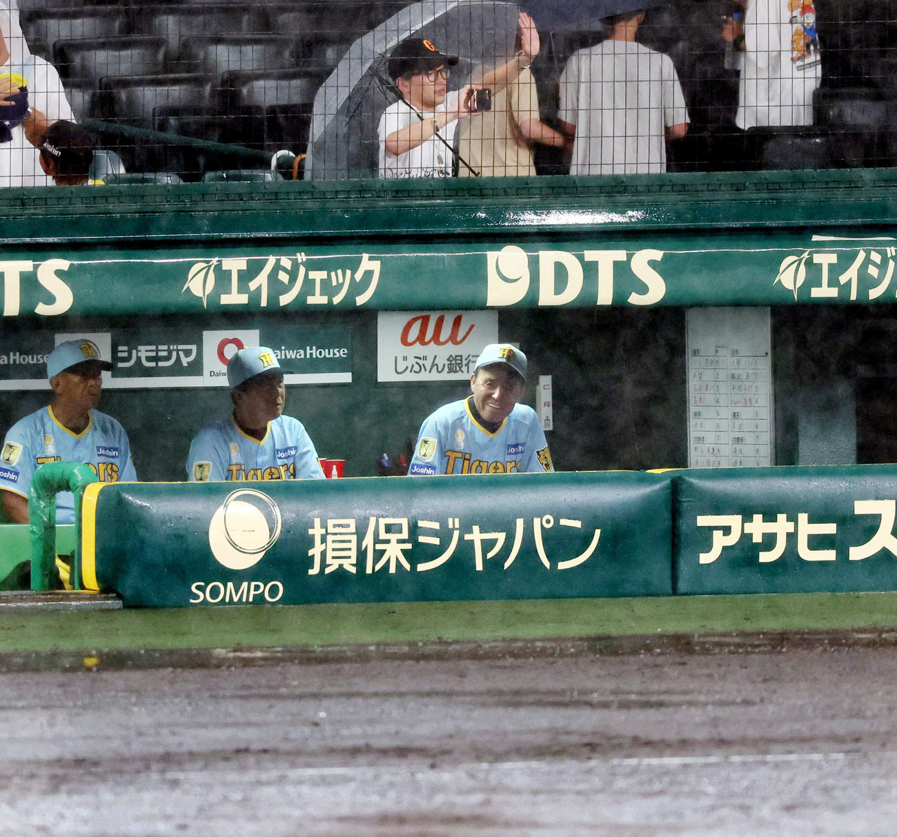 阪神対巨人　7回裏を終え降雨中断となりベンチからグラウンドを見る岡田監督。左は平田ヘッドコーチ（撮影・加藤哉）