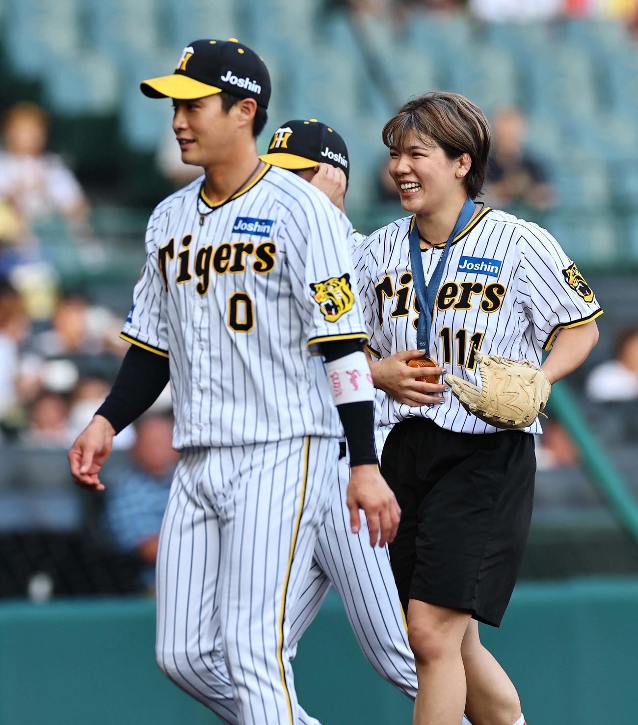 阪神対中日　ファーストピッチセレモニーを務めたパリ五輪女子レスリング76キロ級金メダリストの鏡。左はファンの木浪（撮影・上田博志）