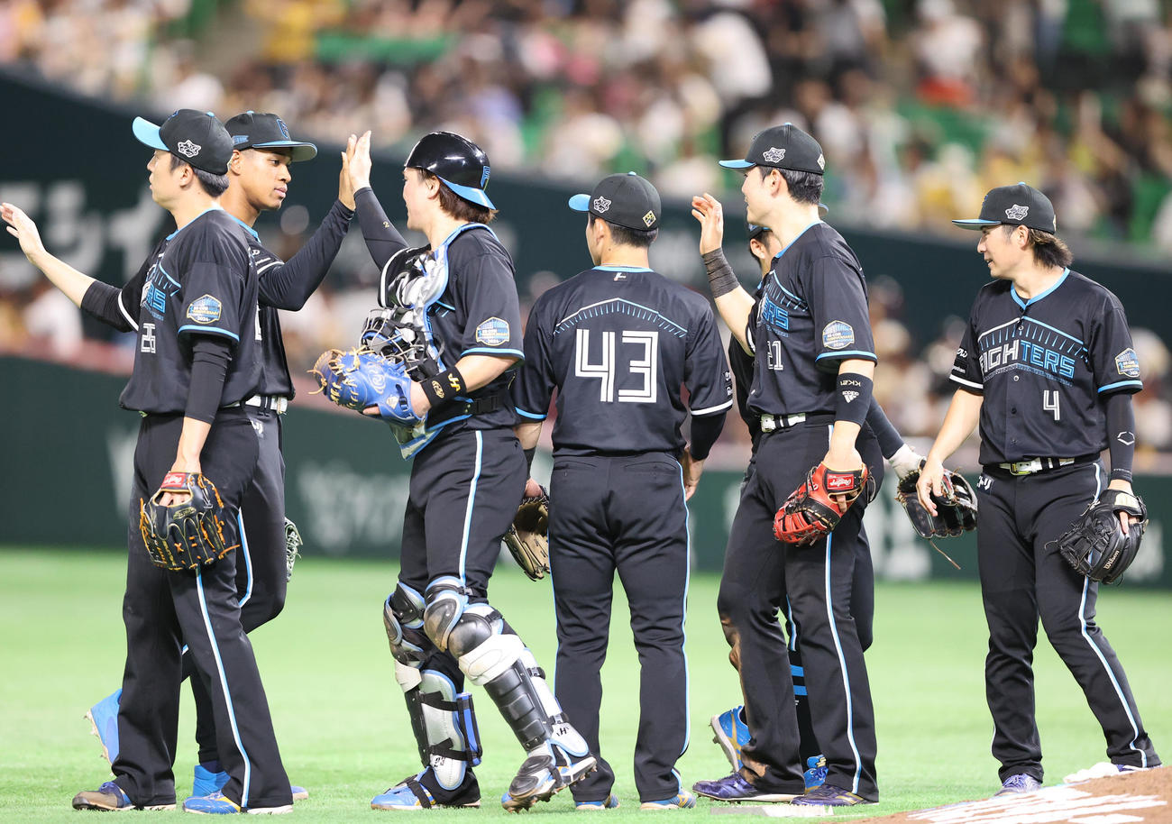 ソフトバンク対日本ハム　ソフトバンクに勝利した日本ハムナインはタッチをかわす（撮影・鬼束羽瑠菜）