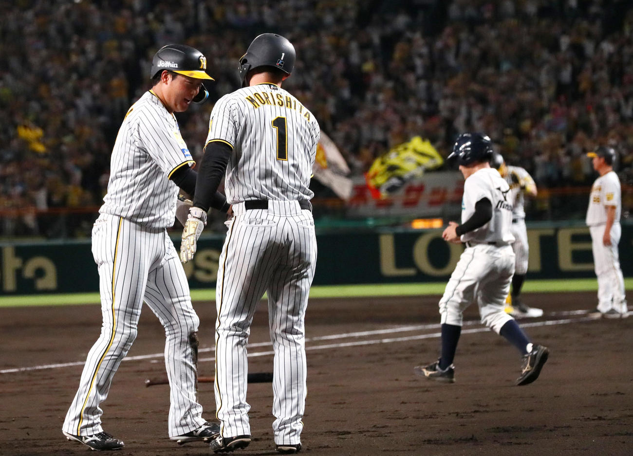 阪神神対中日　1回裏阪神無死二、三塁、佐藤輝の中前2点適時打で生還した二走大山（左）を出迎える三走森下（撮影・上山淳一）