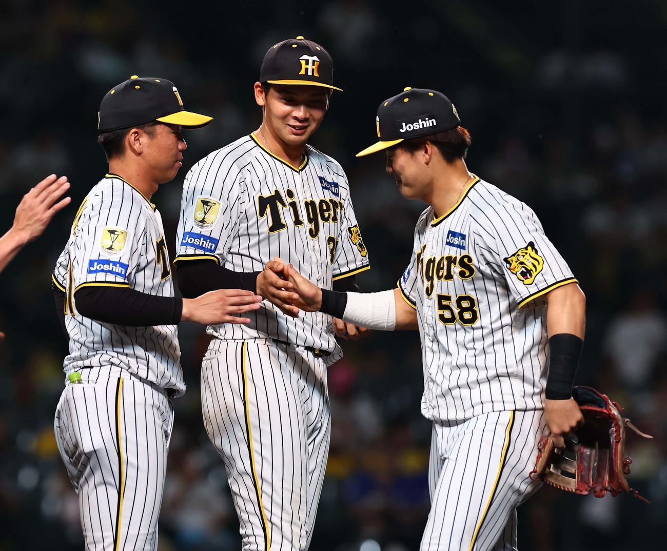 阪神対中日　前川（右）から勝利球を受け取り苦笑いを浮かべる井上（中央）。左は6勝目を上げた村上（撮影・上田博志）
