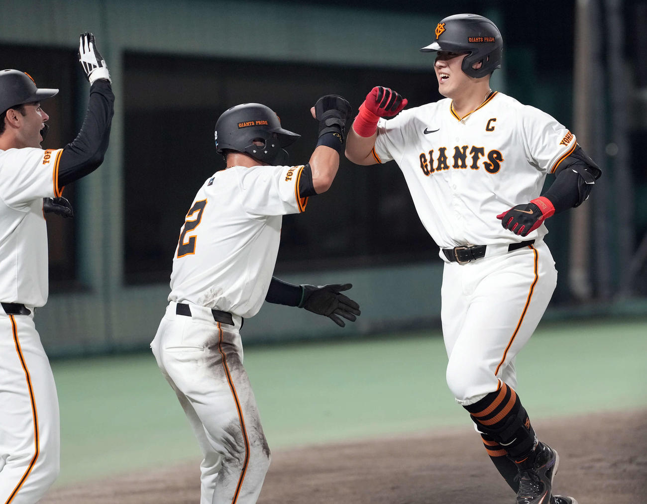 巨人対ヤクルト　5回裏巨人2死一、三塁、右越えに3点本塁打を放ち笑顔を見せる岡本和（右）。左からモンテス、吉川（撮影・たえ見朱実）